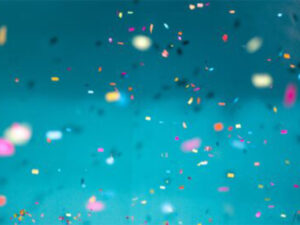 A blue background with multi-color confetti in the air