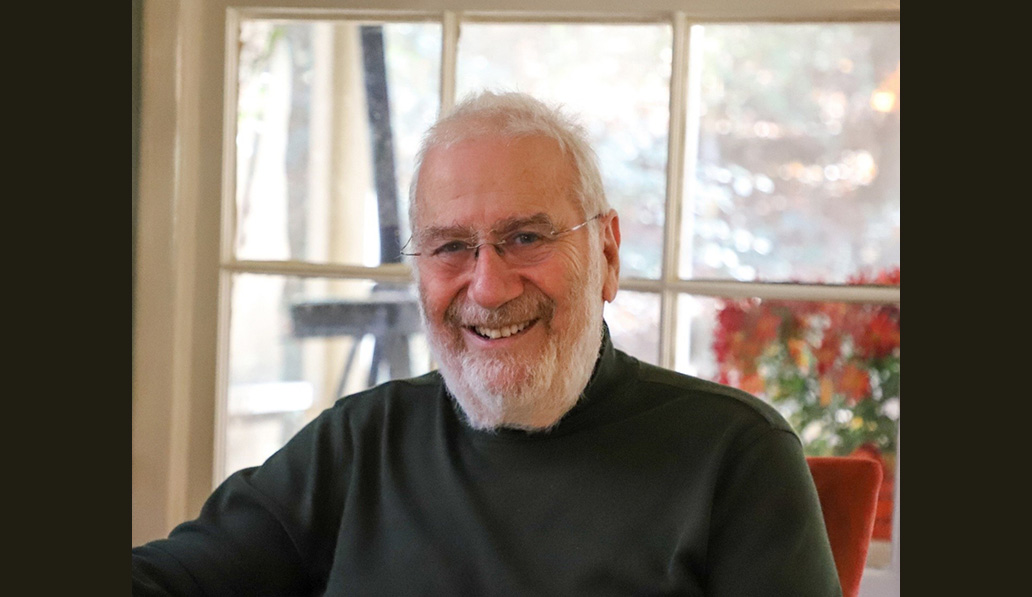 Furniture maker Abraham Tesser in black turtleneck sitting in front of a window.