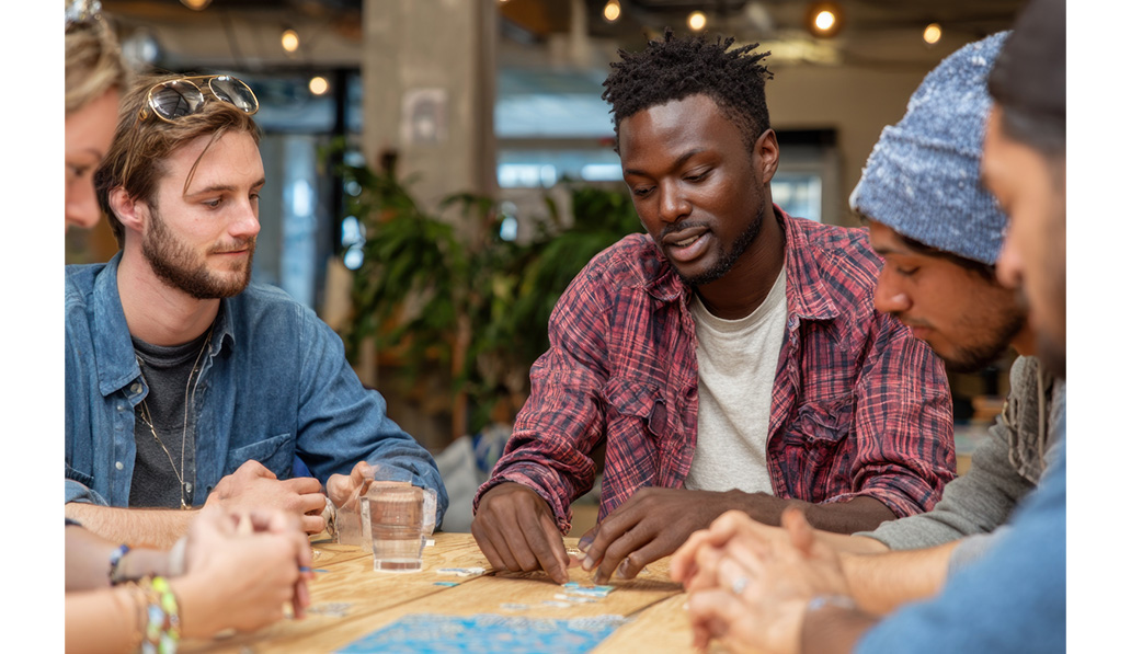 People sitting at table playing board game.