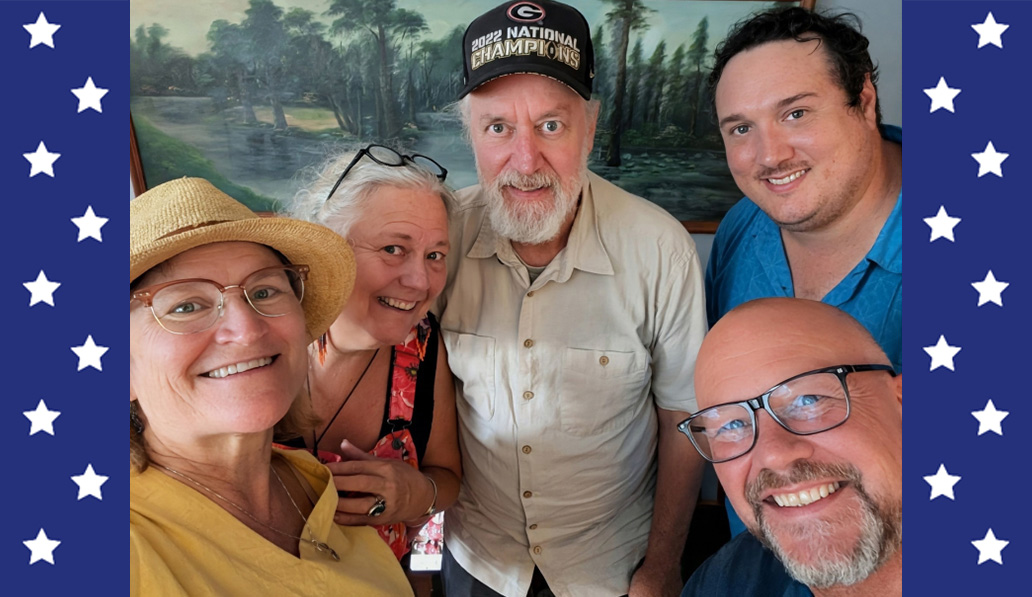 Selfie of members of Solstice Sisters music group in front of painting of trees.